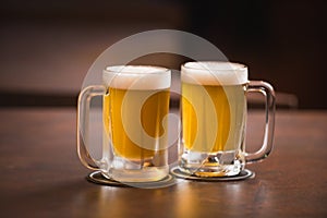 two mugs of chopp on the table.