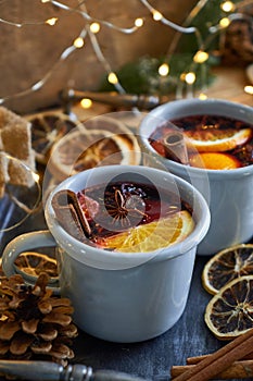 Two mugs with christmas mulled wine with citrus fruits and spices