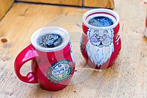 Two mugs filled with hot mulled red wine Gluhwein. Christmas market theme