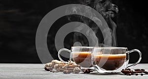 Two mugs of masala tea. Hot indian masala chai tea with milk and spices in a glass glass on dark background. place for text