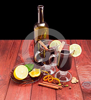 Two mugs with mulled wine, bottle of wine, mulling spices