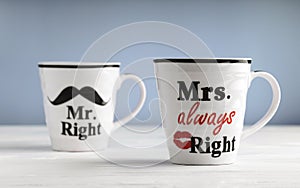 Two mugs with printed text Mr. right and Mrs. always right. Funny phrase about couples life printed on mugs