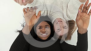 Two mulri racial women friends posing and having fun at studio