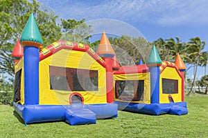 Two multi color castle bounce houses are ready for the kids