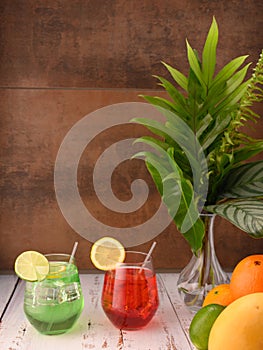 Two multicolored mocktails on wooden grey table. Organic freshness fruits right