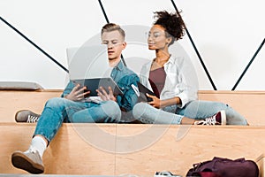 Two multicultural students using laptop