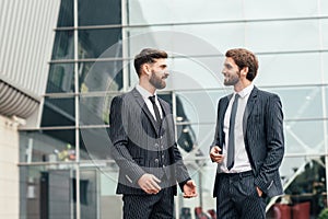 Two multiethnic business partners in formal clothingand talking to each other they finished to work