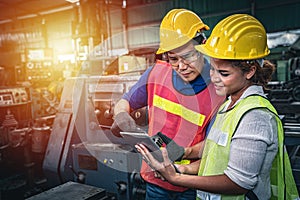 Two multiethnic industrial workers discussing work in the factory.