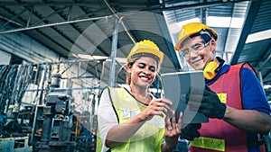 Two multiethnic industrial workers looking at tablet in the warehouse.