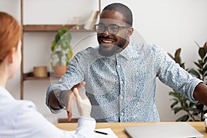 Two multiracial business partners handshaking focus on african-american employee