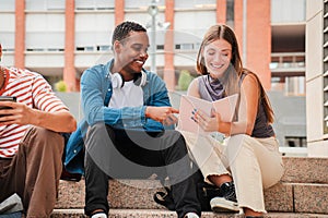 Two multiracial teenage studens learning together at university campus. African american schoolboy talking with a school