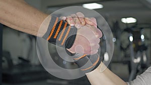 Two muscular men shaking hands at the gym