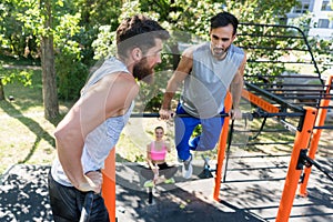 Two muscular young men doing bodyweight exercises in a modern fi photo