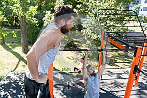 Two muscular young men doing bodyweight exercises in a modern outdoor fitness photo