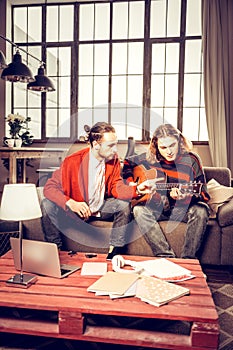Two musicians playing in the band composing new song at home