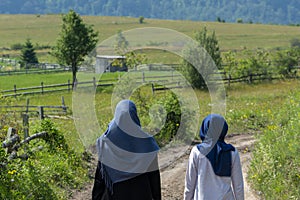 Two muslim girls walking on the rural mountain road