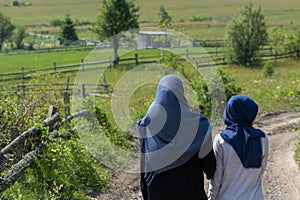 Two muslim girls walking on the rural mountain road