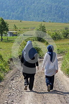 Two muslim girls walking on the rural mountain road