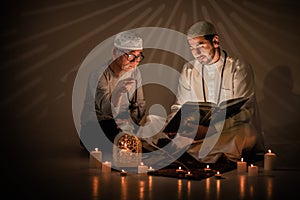Two muslim people study islam quran book together during ramadan photo