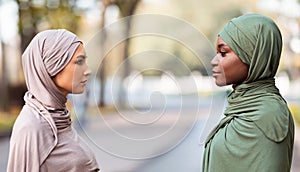 Two Muslim Women Enemies Standing Separately Posing Outdoors, Side-View Portrait photo