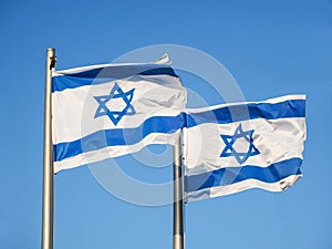 Two national flags of Israel outdoors against the blue sky