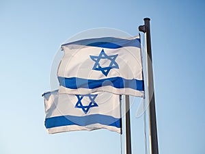 Two national flags of Israel outdoors against the blue sky