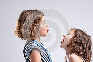 Two naughty young girls sticking out their tongues