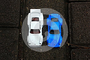 Two Nearly Identical Toy Cars Taken on the Ground photo