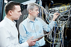 Two network support engineers administrating in server room