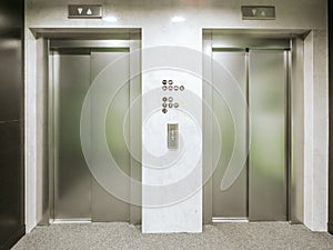 Two new elevators in the hotel. Material is stainless steel. Between the elevators there are floor signs and buttons for