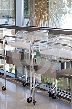 Two newborn bassinets or beds in hospital hallway