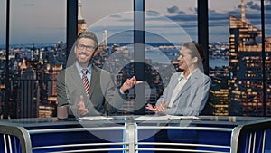 Two newsreaders discussing news evening stage tv studio closeup. Couple talking