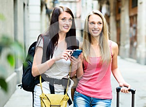 Two nice girls finding path with GPS navigator