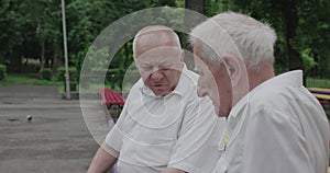 Two nice older men having fun conversation during a meet at park