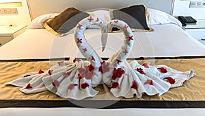Two nice towel swans on a hotel`s bed