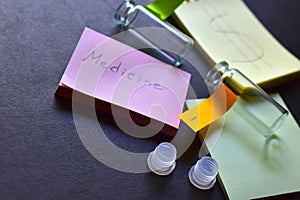 Two notebooks and glass medicine bottles with labels on a black background