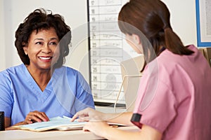 Two Nurses In Discussion At Nurses Station photo