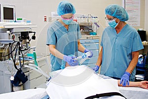 Two nurses with patient in operating room photo