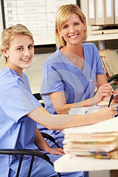 Two Nurses Working At Nurses Station