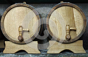 Two oak wooden barrels on racks.