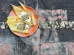 Two Oaxacan tamales with hoja santa wrapped on the outside of the masa photo