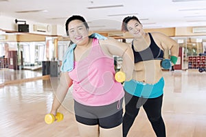Two obese people exercising with dumbbells