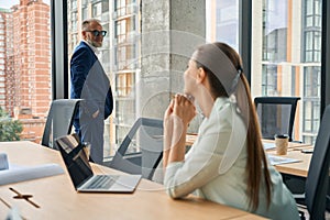 Two office colleagues in nice suits exchanging glances at workplace