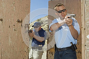 Two Officers Aiming Hand Guns At Firing Range