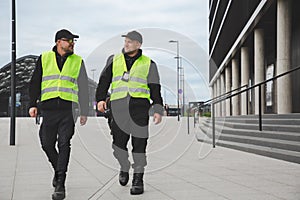 Two officers in reflective vests patrol the streets of the city