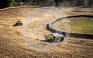 Two offroad RC cars racing on a track