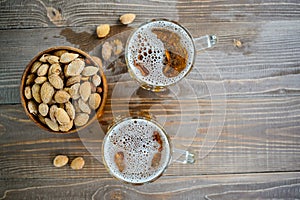 Two Oktoberfest beers with pistachio nuts on a wooden table