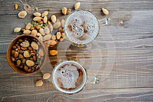 Two Oktoberfest beers with pistachio nuts on a wooden table