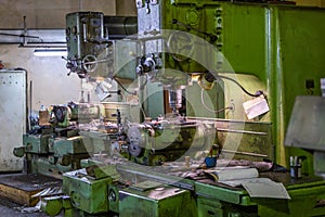 Two old and big soviet vertical 5-axis industrial milling and boring machines indoors with selective focus and blur