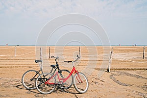 two old bikes at the beach in front of the sea